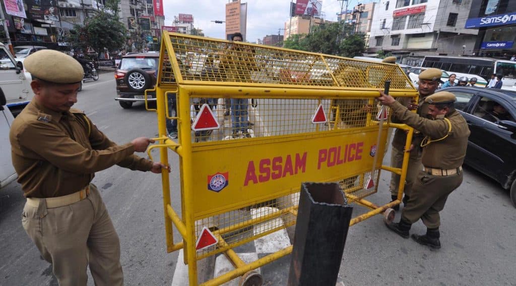Police personnel carrying barricades